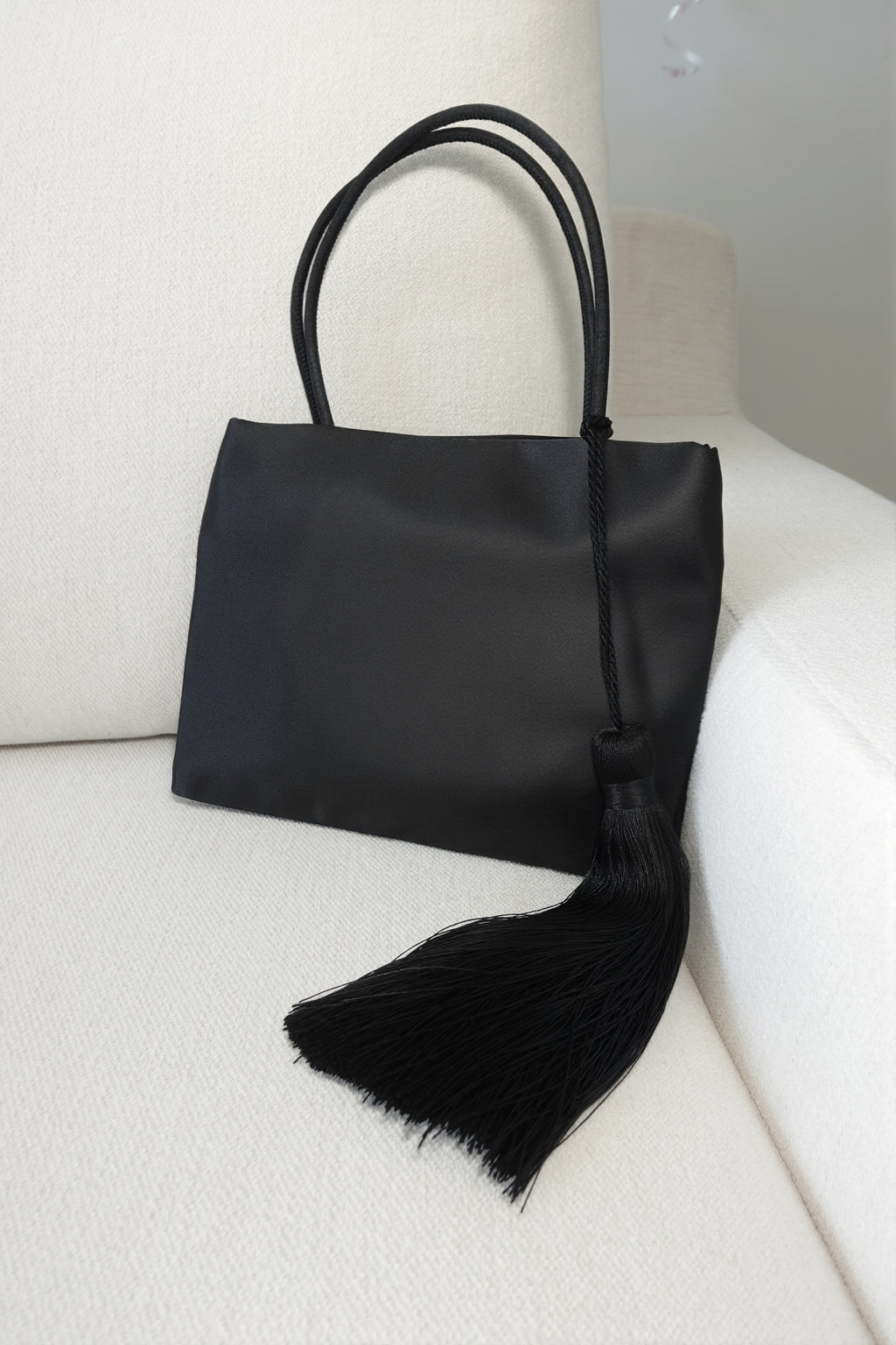 Minimalist Black Nylon Top Handle Bag with Statement Silk Tassel Accent