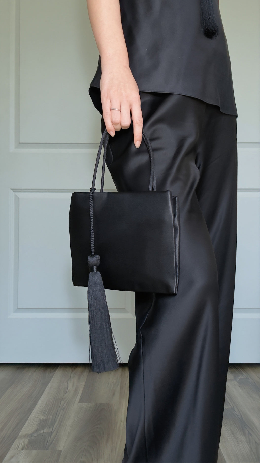 Minimalist Black Nylon Top Handle Bag with Statement Silk Tassel Accent