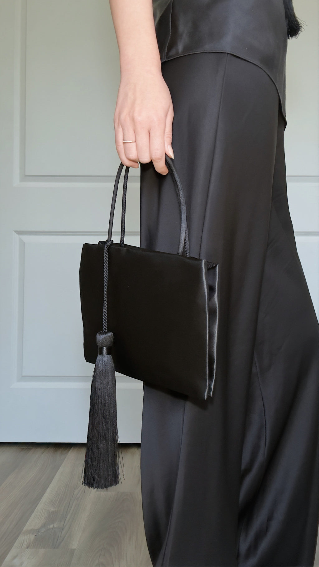 Minimalist Black Nylon Top Handle Bag with Statement Silk Tassel Accent