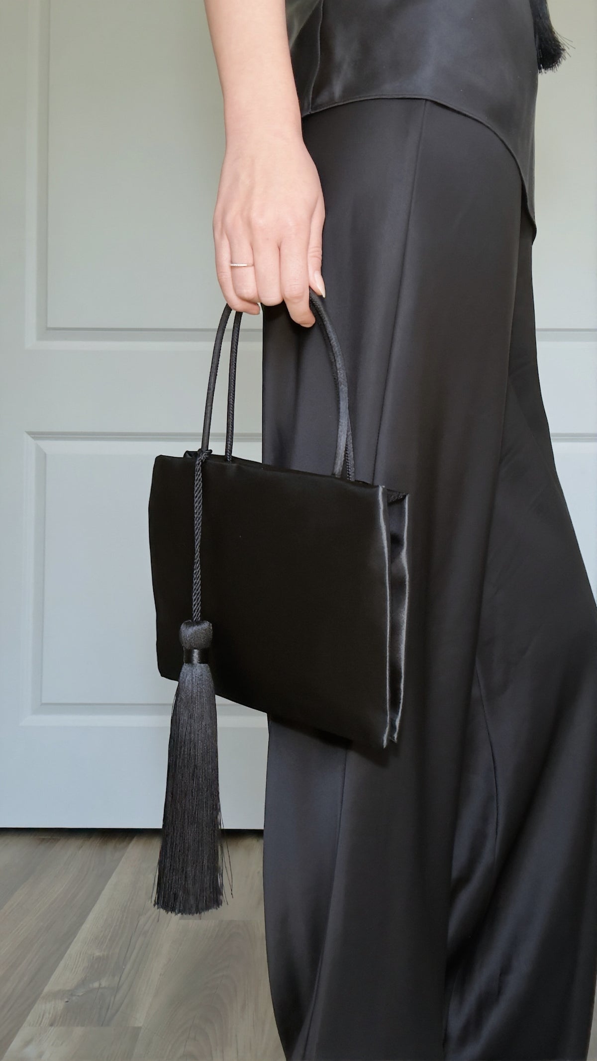 Minimalist Black Nylon Top Handle Bag with Statement Silk Tassel Accent
