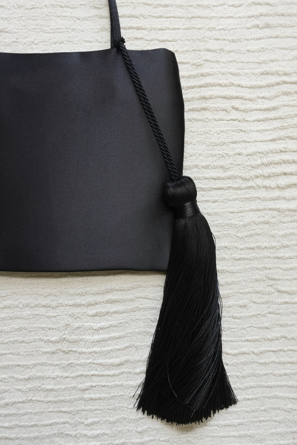 Minimalist Black Nylon Top Handle Bag with Statement Silk Tassel Accent