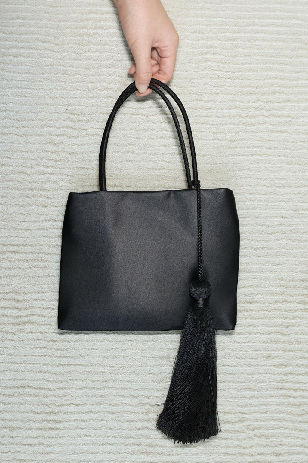 Minimalist Black Nylon Top Handle Bag with Statement Silk Tassel Accent