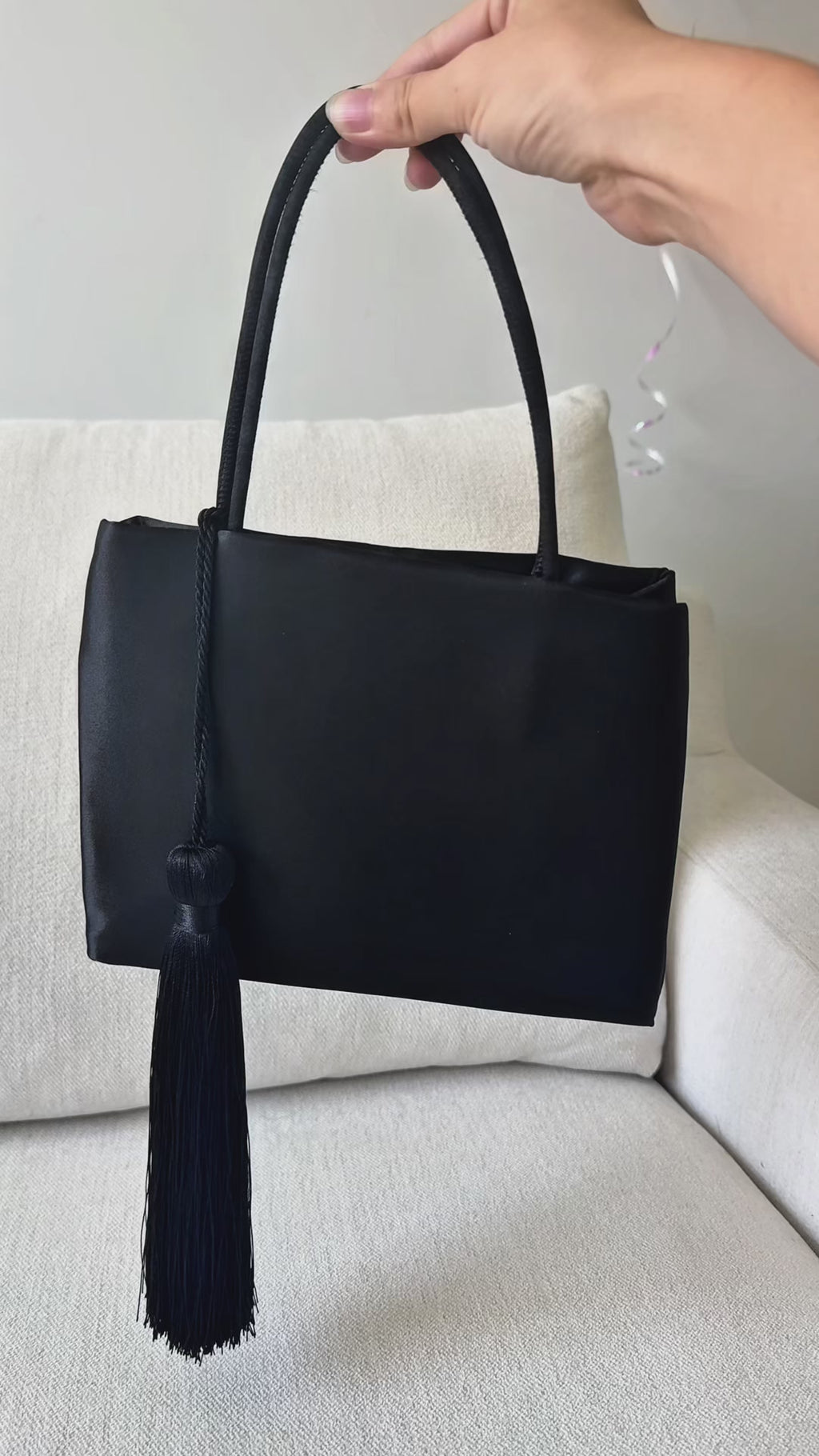 Minimalist Black Nylon Top Handle Bag with Statement Silk Tassel Accent